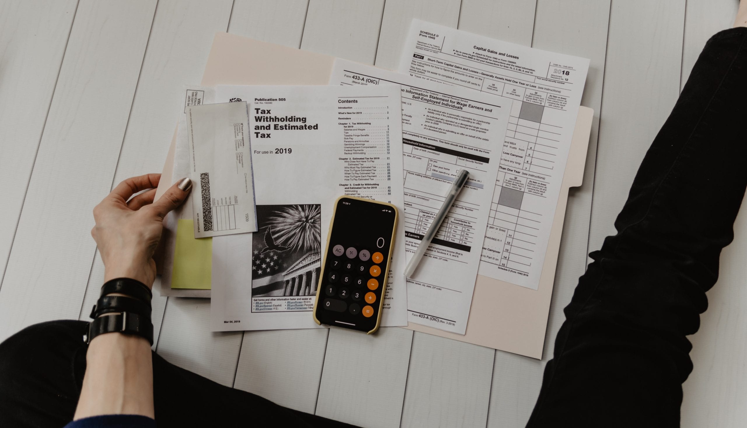 Budget your money person holding paper near pen and calculator